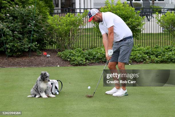 Professional golfer Marc Leishman of Australia hits the ball to the green in his backyard while his dog Doc looks on June 02, 2020 in Virginia Beach,...