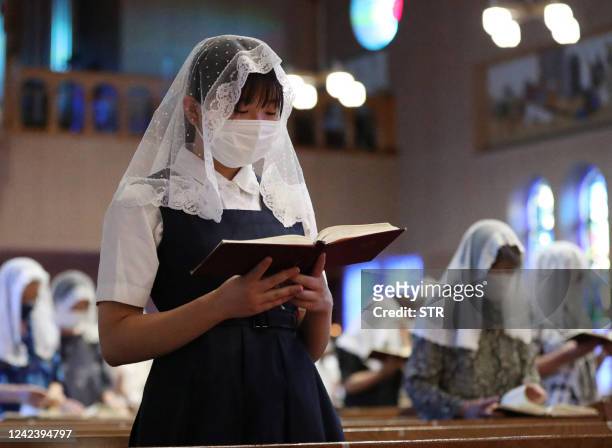 People offer prayers for the victims at a mass at Urakami Cathedral in Nagasaki on August 9 on the 77th anniversary of the atomic bombing during...