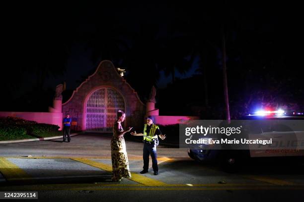 Woman talks to Palm Beach police officer in front of former President Donald Trump's house at Mar-A-Lago on August 8, 2022 in Palm Beach, Florida....