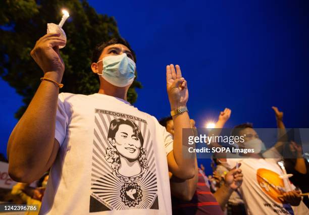 Activists hold candles and raise three finger salutes during the anniversary of the '8888 Uprising' at Tha Phae Gate in Chiang Mai. On the 8th of...