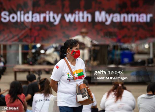 An activist stands in front of a banner that says "Solidarity with Myanmar" during the anniversary of the '8888 Uprising' at Tha Phae Gate in Chiang...
