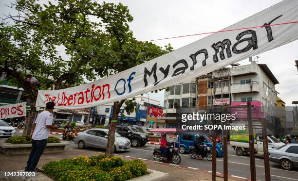Activists install a banner that says "The Liberation of Myanmar" during the anniversary of the '8888 Uprising' at Tha Phae Gate in Chiang Mai. On the...