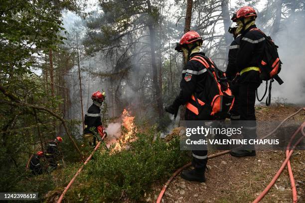 Firefighters light fires in Mostuejouls, southern France, on August 9 as a prophylactic measure aimed at slowing the advance of a fire underway in...