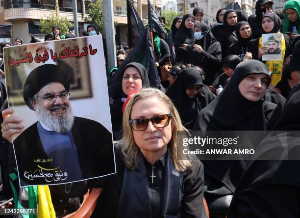 Christian supporter of Lebanon's Hezbollah lifts a placard depicting the group's leader Hassan Nasrallah, during a procession to mark Ashura, a...