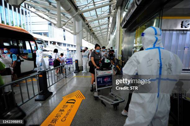 Tourists go through pre-departure formalities at the Sanya Phoenix airport as stranded holidaymakers prepare to leave the Covid-hit resort city of...