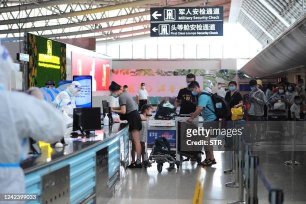 Tourists go through pre-departure formalities at the Sanya Phoenix airport as stranded holidaymakers prepare to leave the Covid-hit resort city of...