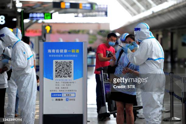 Tourist goes through pre-departure formalities at the Sanya Phoenix airport as stranded holidaymakers prepare to leave the Covid-hit resort city of...