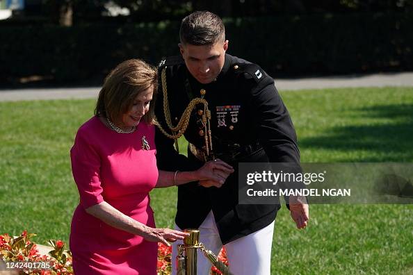A White House military aide assists US House Speaker Nancy Pelosi