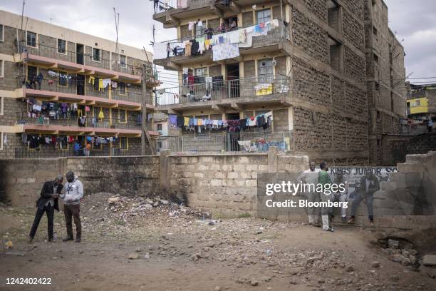 Residents gather outside the Mathare North Social Hall polling station, surrounded by residential apartment blocks, during the presidential election...