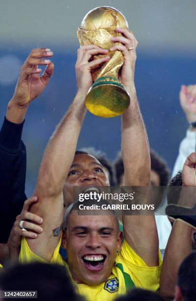 Brazil's forward Ronaldo hoists the World Cup trophy during the award ceremony at the International Stadium Yokohama, Japan, 30 June, 2002 following...
