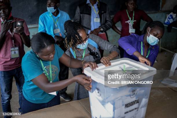 Independent Electoral and Boundaries Commission officials break the seal of ballot boxes before counting during Kenya's general elections at a...