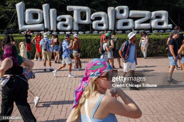 Attendees walk past a Lollapalooza sign during the first day of Lollapalooza in Grant Park on Thursday, July 29 in Chicago.