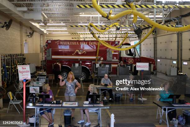 Poll workers and voters participate during Wisconsins state primary day on August 9, 2022 at the Village Hall of Waukesha in Waukesha, WI. The race...
