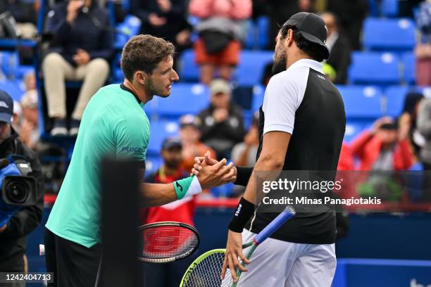 Pablo Carreno Busta of Spain shakes hands with Matteo Berrettini of Italy after his victory during Day 4 of the National Bank Open at Stade IGA on...