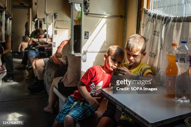 Two children play with their cellphone on the evacuation train going to Dnipro. As fighting has intensified in eastern Ukraine, the evacuation of...