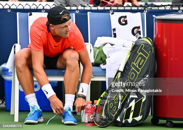 Holger Rune of Denmark ties his laces prior to his match against Fabio Fognini of Italy during Day 4 of the National Bank Open at Stade IGA on August...