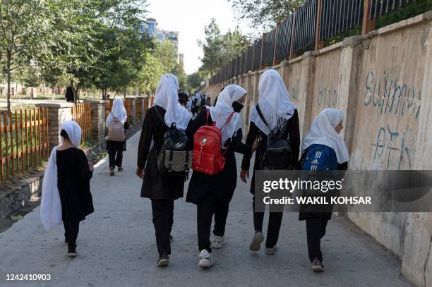In this picture taken on August 9 Afghan primary schoolgirls walk to their school along a street in Kabul. - One year on from the Taliban's return to...