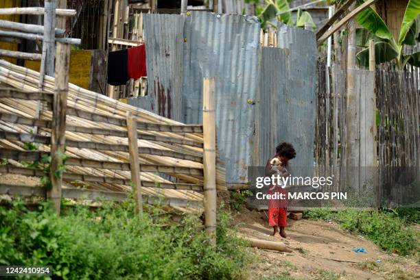 Girl plays with a dog in the Cañaveral neighbourhood of the Ciudad de Dios cooperative in the Monte Sinai sector of Guayaquil, Ecuador, on July 26,...