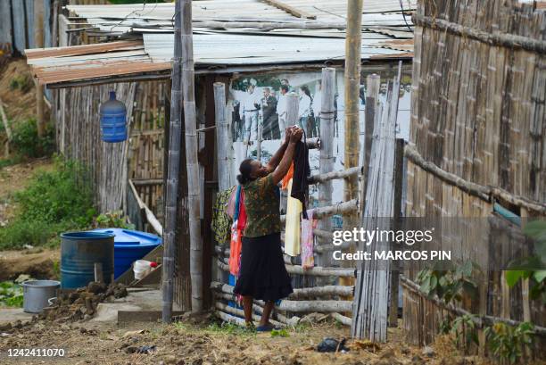 Woman hangs clothes on a fence in the Cañaveral neighbourhood of the Ciudad de Dios cooperative in the Monte Sinai sector of Guayaquil, Ecuador, on...