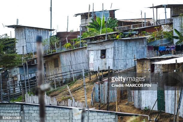 Woman looks out of the window of a house in the Cañaveral neighbourhood of the Ciudad de Dios cooperative in the Monte Sinai sector of Guayaquil,...