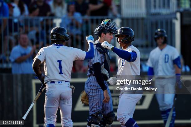 Juan Carlos Negret of the Davenport Blue Sox is greeted by teammate Tyler Tolbert after hitting a two-run home run in the first inning during the...