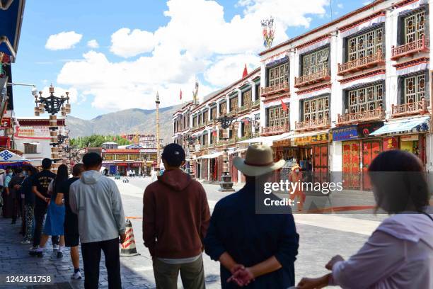 This photo taken on August 9, 2022 shows people queue to undergo nucleic acid tests for the Covid-19 coronavirus in Lhasa, in China's western Tibet...