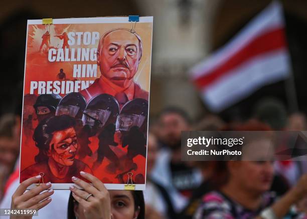Protester holding a poster with an image of the Belarusian leader with words 'Stop Calling Him President'. Members of the local Belarusian and...