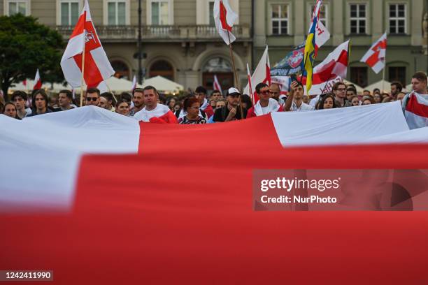 Protesters carry a geant historical flag of Belarus . Members of the local Belarusian and Ukrainian diaspora supported by local Cracovians during the...