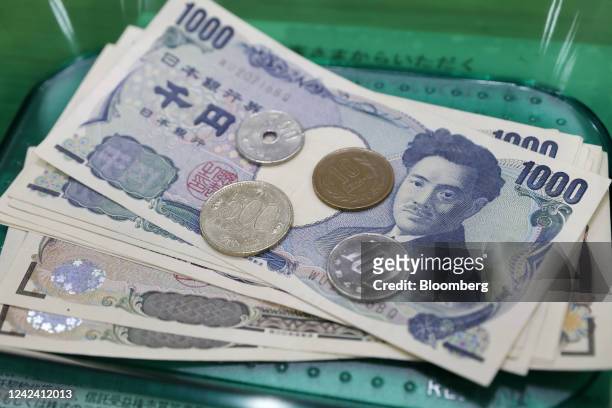 Japanese yen coins and banknotes on a tray arranged at a branch of Resona Bank Ltd. In Tokyo, Japan, on Tuesday, Aug. 9, 2022. Dollar-yen, which...