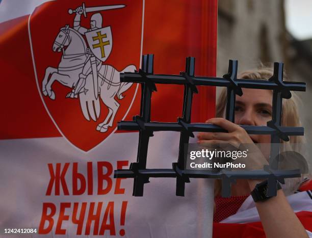 Protester carries symbolic paper prison bars representing the Belarusian population in prisons and the lack of freedom in Belarus. Members of the...