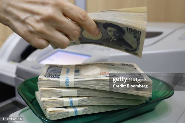 Bundles of Japanese 1,000 yen banknotes on a tray at a branch of Resona Bank Ltd. In Tokyo, Japan, on Tuesday, Aug. 9, 2022. Dollar-yen, which soared...