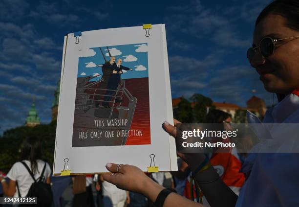 Protester holding a poster with an image of the Belarusian and Russian leaders with words 'This Warship Has Only One Direction'. Members of the local...