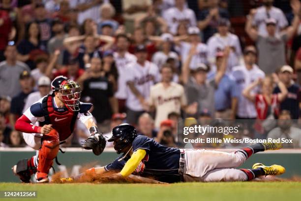 Ronald Acuna Jr. #13 of the Atlanta Braves slides as he beats the tag of Kevin Plawecki of the Boston Red Sox to score during the eleventh inning of...