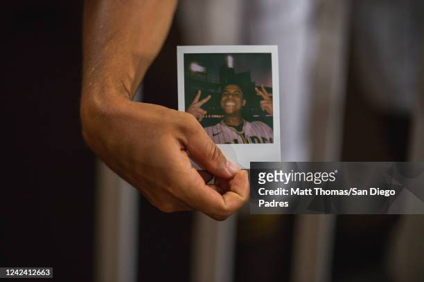 Member of the San Diego Padres holds up a polaroid photo of Juan Soto after his home run in the fourth inning during the game against the San...
