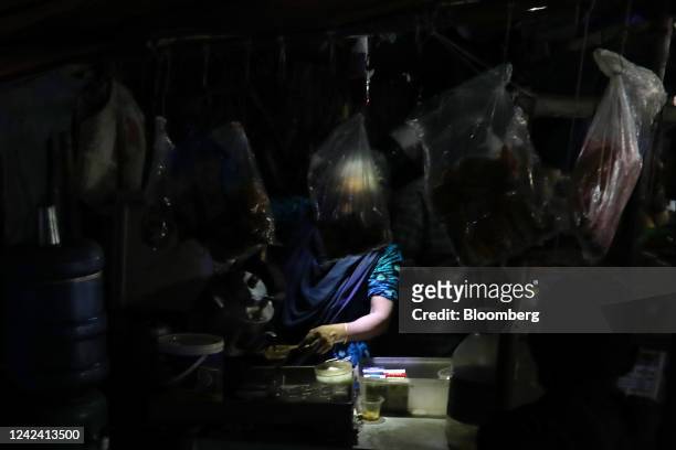 Woman makes tea under a USB-powered LED light during a load-shedding power outage period in Dhaka, Bangladesh, on Tuesday, Aug. 9, 2022. Bangladesh...