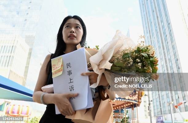 Zhou Xiaoxuan, also known as Xianzi, a feminist figure who rose to prominence during China's #MeToo movement, holds a bouquet of flowers as she...