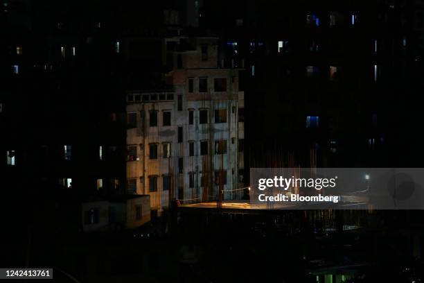 Construction workers work with power supplied by generators during a load-shedding power outage period in Dhaka, Bangladesh, on Tuesday, Aug. 9,...
