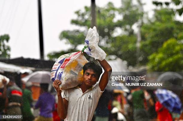 Rohingya refugee walks back to his house after collecting relief material in Kutupalong refugee camp in Ukhia on August 10, 2022.