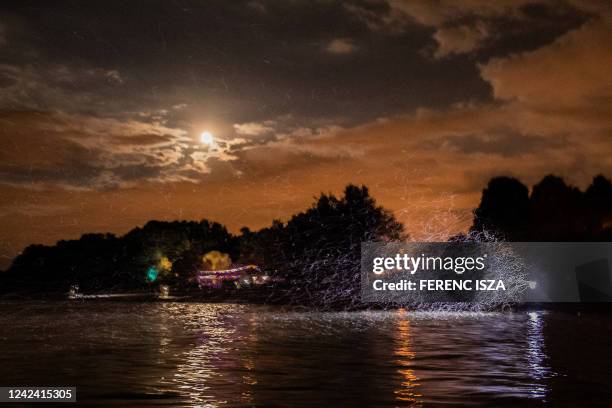 Swarm of mayflies flies over the surface of the river Danube after sunset in Szentendre, north of Budapest, Hungary, on August 9, 2022. Mayflies...