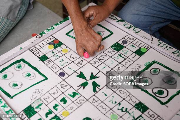 With a friend's help, a leprosy patient plays Ludo, a strategy board game outside their ward at The Leprosy Mission at Nepal's Anandaban Hospital in...