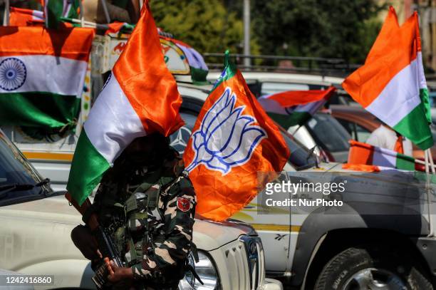 Trooper stands alert near a BJP Flag and Indian National Flag. BJP workers held Tri-Color Rally in Baramulla Jammu and Kashmir India on 10 August...