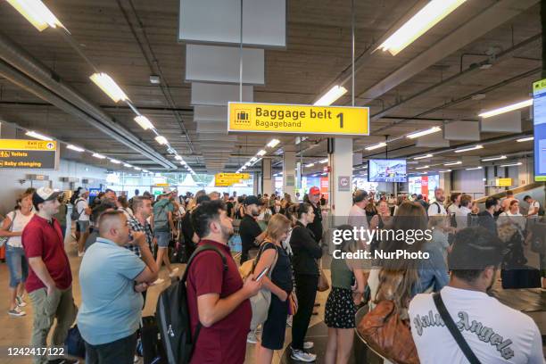 Passengers wait for their luggage at the arrivals baggage belt area of Eindhoven airport. Long delays, lines, crowds and queues are formed at the...