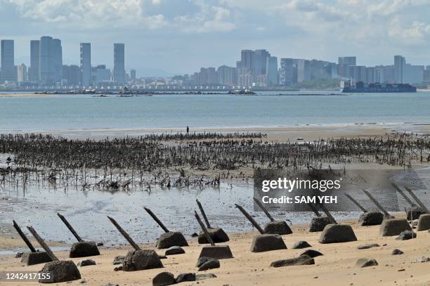 The Xiamen city skyline on the Chinese mainland is seen past anti-landing spikes placed along the coast of Lieyu islet on Taiwan's Kinmen islands,...