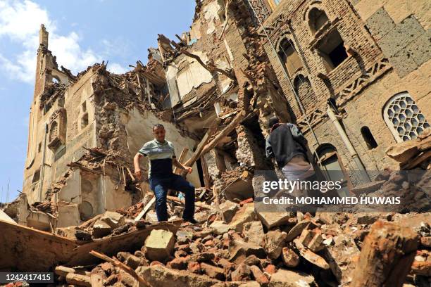 People inspect a collapsed UNESCO-listed building in the old city of the Yemeni capital Sanaa on August 10, 2022 following heavy rains.