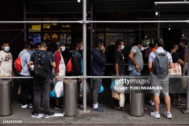 Group of migrants from Texas wait in line outside Port Authority Bus Terminal to receive humanitarian assistance on August 10, 2022 in New York. -...