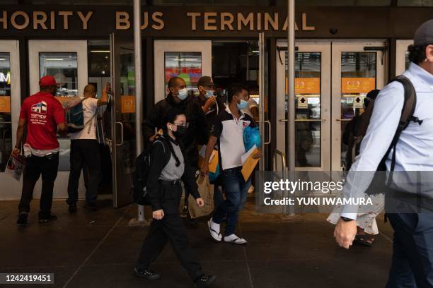 Group of migrants walks out of Port Authority Bus Terminal after their bus arrived from Texas on August 10, 2022 in New York. - Texas has sent...