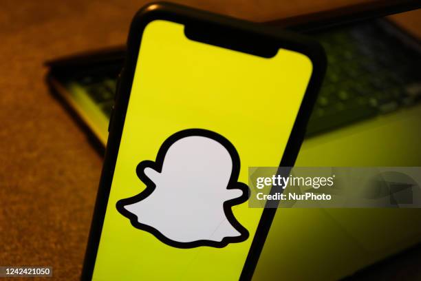 Snapchat logo displayed on a phone screen is seen with a laptop in the background in this illustration photo taken in Krakow, Poland on August 10,...