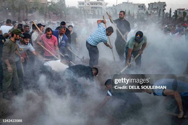 Men dig a grave during the funeral of a fighter of the Syrian Democratic Forces in Syria's northeastern Kurdish-majority city of Qamishli on August...