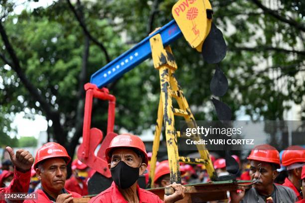 Workers of the state company Petroleos de Venezuela carry a model of an oil well during a demonstration in support of President Nicolas Maduro in...