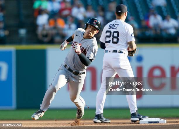 Steven Kwan of the Cleveland Guardians rounds second base past Javier Baez of the Detroit Tigers on a triple during the first inning at Comerica Park...